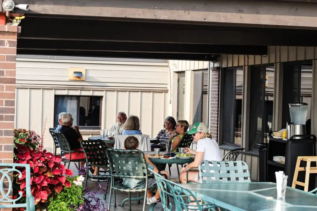 Customers sitting and enjoying beverages and conversation on Red River Kitchen patio